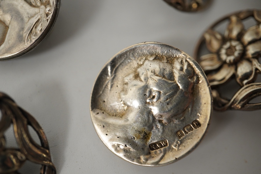 A pair of Art Nouveau enamelled white metal buttons, 33mm, a set of 3 cast silver flower buttons, H.C. Birmingham 1911, 23mm, a pair of silver lily pattern buttons, J.G. Birmingham 1903, 27mm and a pair of cast silver Ar